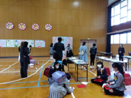 うちわにメッセージを書く小学生たちの写真