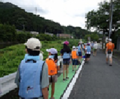 上級生が引率して地域の方に見守られて河原へ移動中の写真