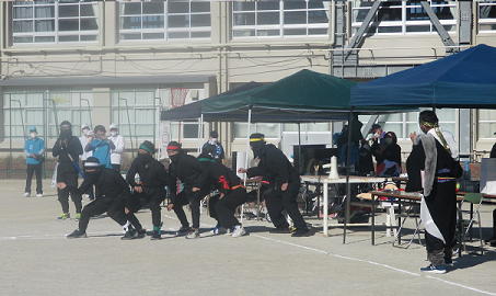 忍者装束でデモンストレーションするおやじの会の皆さんの写真