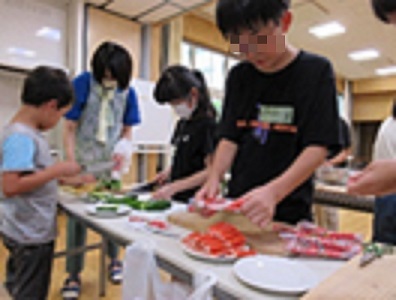 ネタとシャリを海苔で巻く子ども達の様子