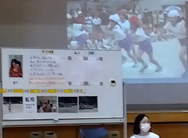 講師が成長の様子をプロジェクターや年表で示しながら講演をしている様子