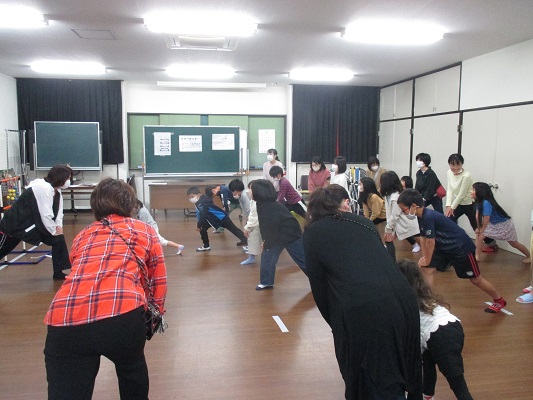 子どもたちと保護者がストレッチをする画像