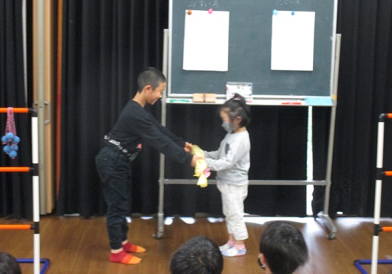 新一年生に上級生から入学御祝いが手渡される画像