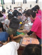 子ども達がテーブルの上のたくさんのお土産の中からどれにしようか選んでいる様子