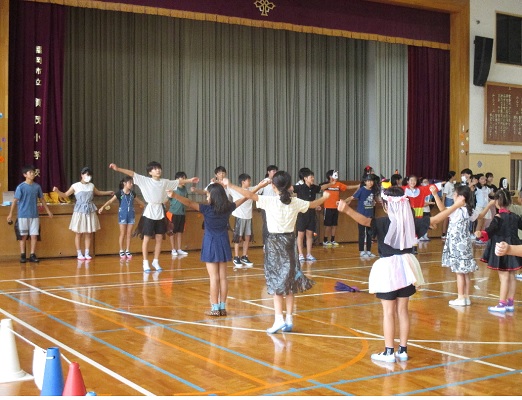 子どもリーダーが前に立ち、全員で準備体操をしている様子