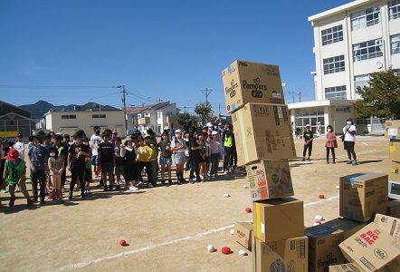 段ボールの牢屋を壊して捕虜を解放しようと、玉をぶつける子どもたち