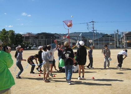 網に入った玉の数の捕虜を解放できるため、青空の下玉入れをしている様子