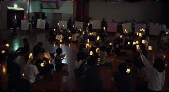 子どもたちが牛乳パックで作った灯篭を灯しているようす