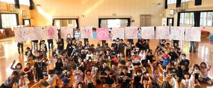 子どもたちが描いた障子アートをバックにした集合写真