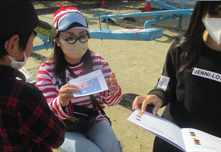 アイマスク姿の「寝不足Wさん」からクイズ用紙を受け取る子どもたちのようす