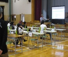 体育館でプロジェクターを見ながらの講演会のようす