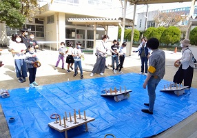 子どもたちが３台の的に輪を投げる画像