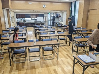 15組の家族を待つ、長机と椅子が並んでいる会場の様子