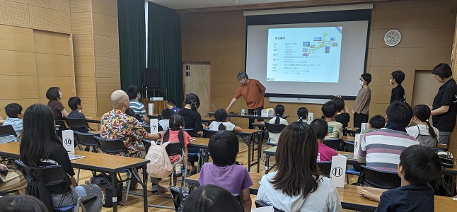 保護者やきょうだいと並んで座って、講師の話を聴いている会場の様子