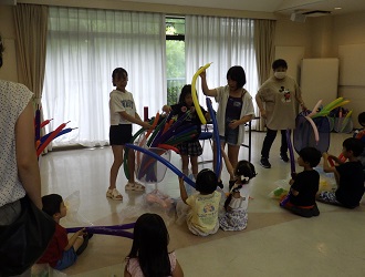 高学年の3人が、バルーンを下級生に配っている様子