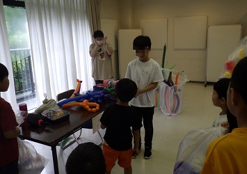 役員が用意したお祝い品を、5年生男子が1年生男子に渡している様子