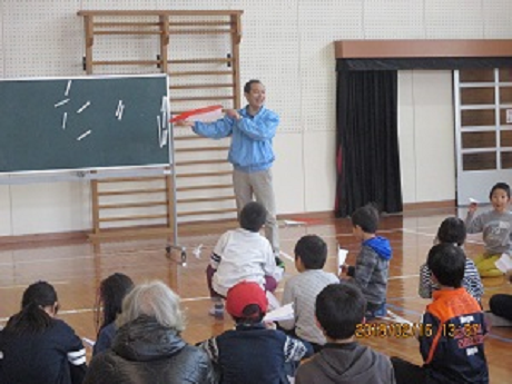 子どもたちに紙ヒコーキの折り方を説明する様子2