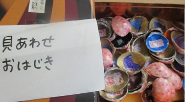 ハマグリに絵を描き布でくるんだお手製の貝合わせ