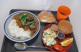 スタッフ調理のカレーやサラダに、寄贈された果物やパンなどが添えられています