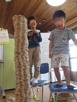 積み木遊び、どんどん高く、椅子を持ち出してもっと高く。