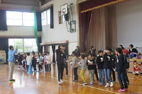 子どもたちが紙ヒコーキを飛ばす順番で並び待っている様子