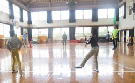 子どもたちが三角コーンめがけて紙ヒコーキを飛ばしている様子