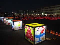 校庭に並んだランタンに火がともっている様子