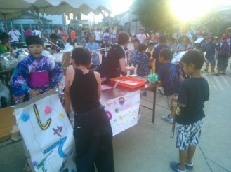 夏祭りに出店し、客を呼びこむ子どもたちの写真
