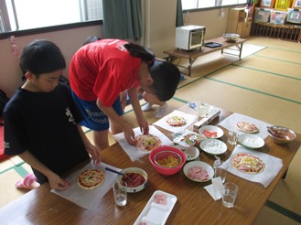 ピザを皿に載せる子どもの写真