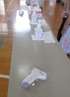 体育館入口の受付に非接触体温計と手指消毒セット