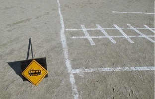 白線で描いた模擬踏切と踏切を示す標識の写真