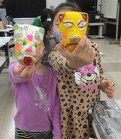 お面を持った2人の女の子の写真