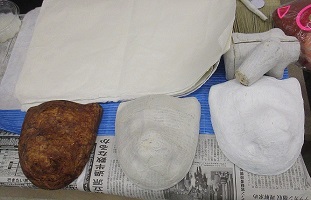 柿渋を塗った木型に和紙を貼って乾かしているお面の写真