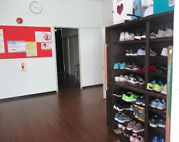 集会所の入り口、整然とした靴箱の写真