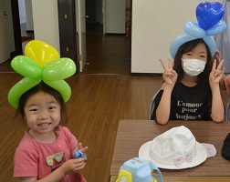 笑顔でバルーンの冠をかぶる子どもたちの写真