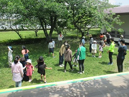 芝生の上でじゃんけんなどをする様子の写真