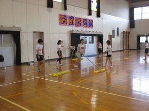 体育館のモップがけをする子どもリーダーの写真