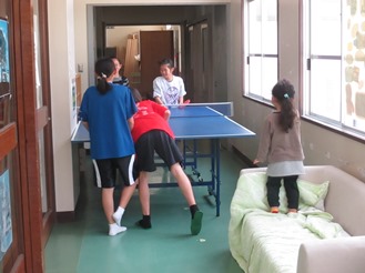 廊下の卓球台で遊ぶ子どもたちの写真
