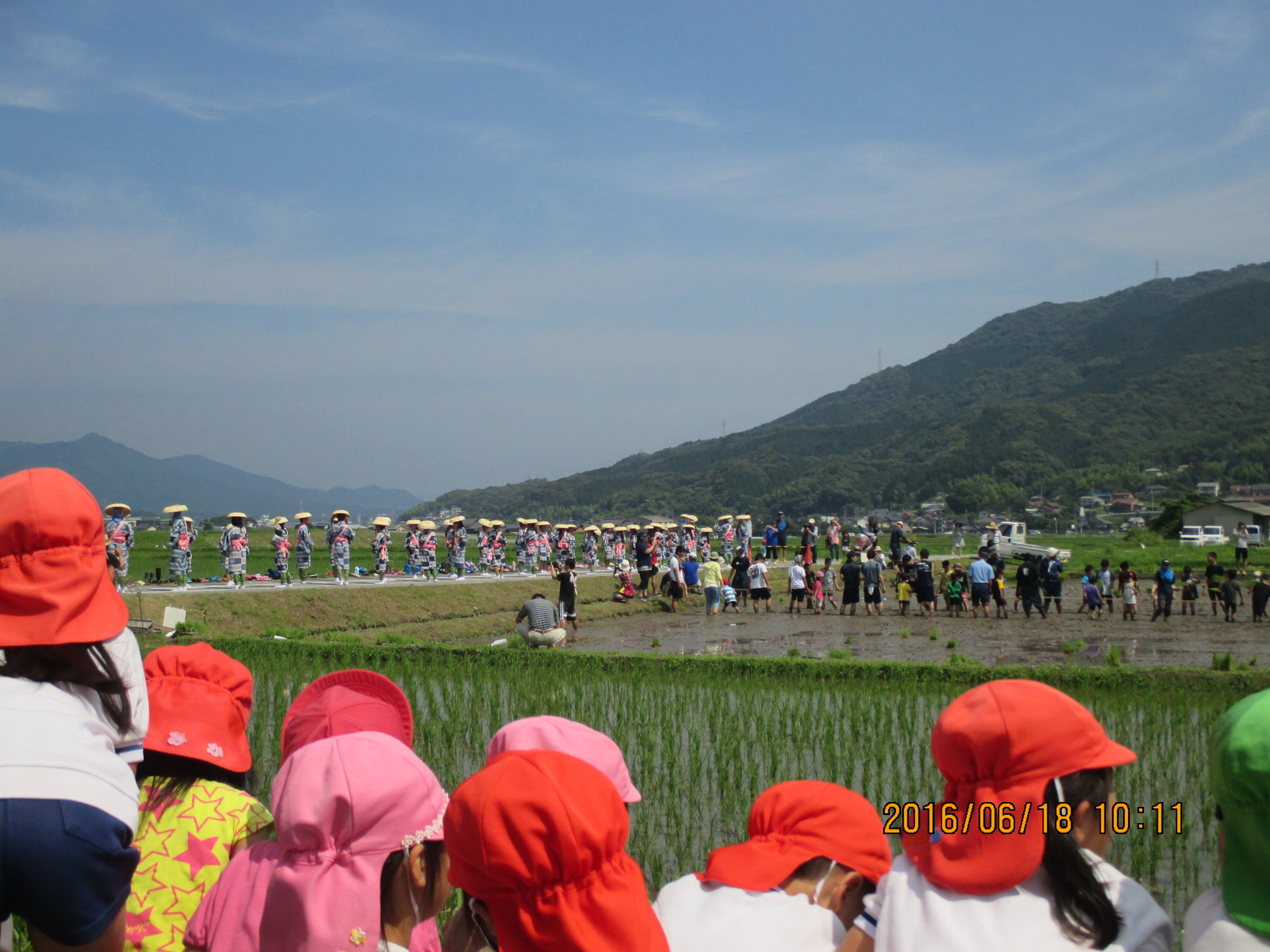 お田植え舞を見学する子どもたち。青空が広がっています