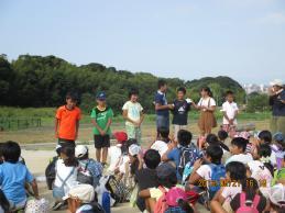 参加者たちの前で整列する子どもリーダーの写真