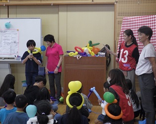 遊びの達人と育成に見守られながら、子ども達の前で挨拶する６年生男子