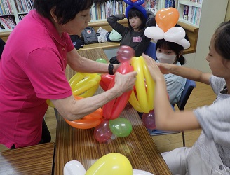講師の指導で、色とりどりのバルーンで冠を作る真剣な子ども達。