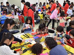 九大生の指導で法被を作っている画像