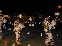 灯明に浮かぶ踊りの輪の画像