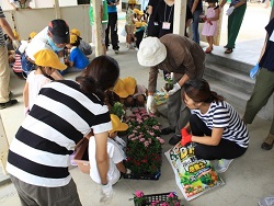 親子で季節の花の植え替えをしている写真