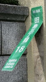 折れ曲がっている街区表示板