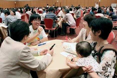 若い男性や社会人、子供連れのお母さんがテーブルで対話しているところ