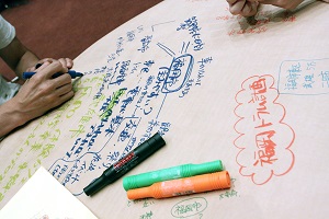 テーブルクロス（模造紙）にメモを書いているところ