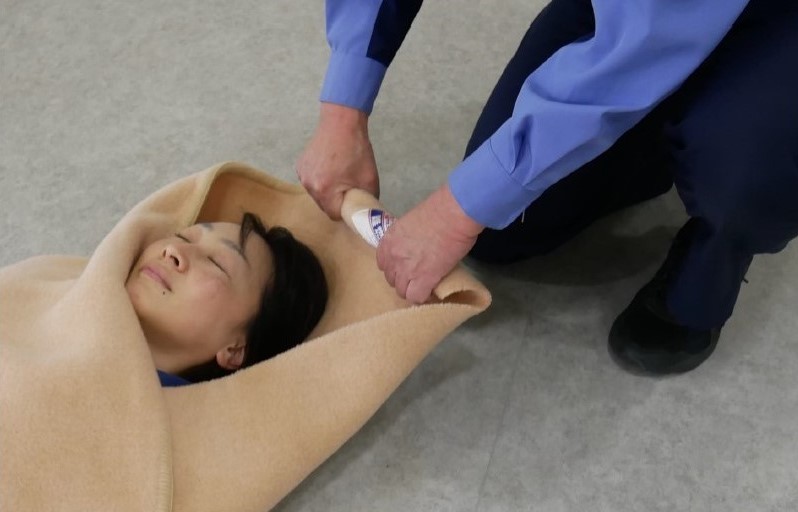 ４　傷病者の頭上の毛布を角から数回巻き，搬送者の持ち手を作る。