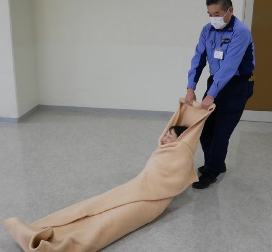 ５　搬送者は持ち手をつかみ，後方に引きずりながら搬送する。